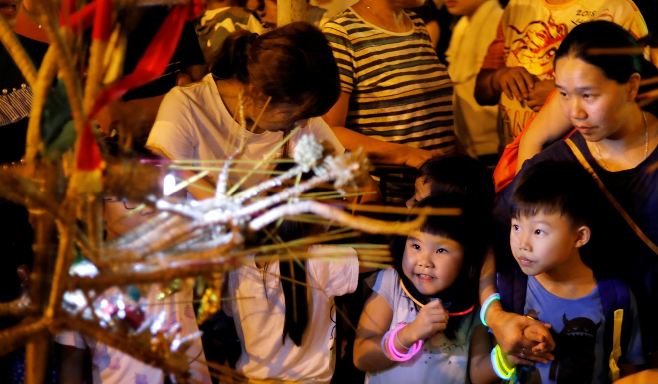 Hong Kong families attend the fire dragon dance event to celebrate the Mid-Autumn Festival, at Pok Fu Lam Village on September 24. The government plans to extend maternity leave from 10 to 14 weeks, and is expected to subsidise part of the employers’ cost burden as a result of the move. Photo: Reuters