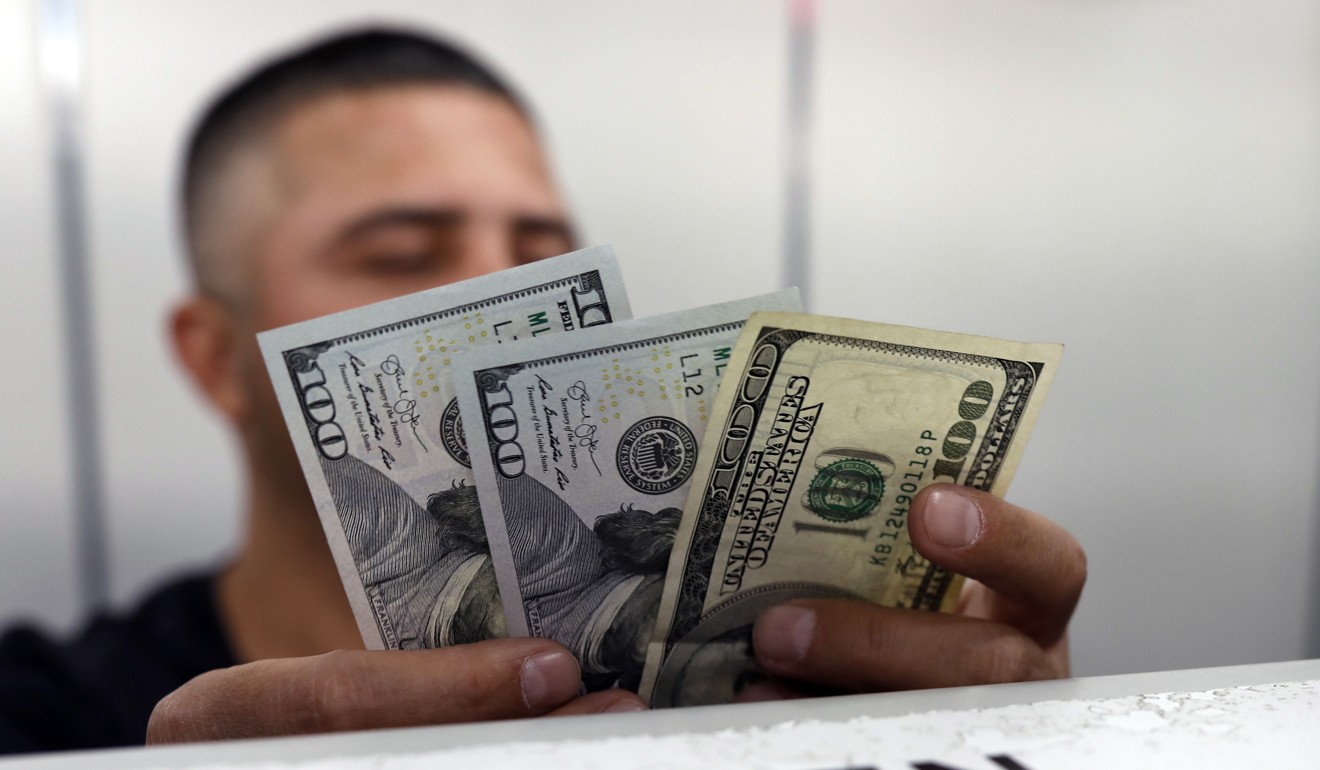 An official checks US dollar banknotes before changing them for Turkish lira inside a currency exchange office in Ankara, Turkey, on August 17. The value of the lira has tumbled significantly against the dollar in recent months. Photo: AP