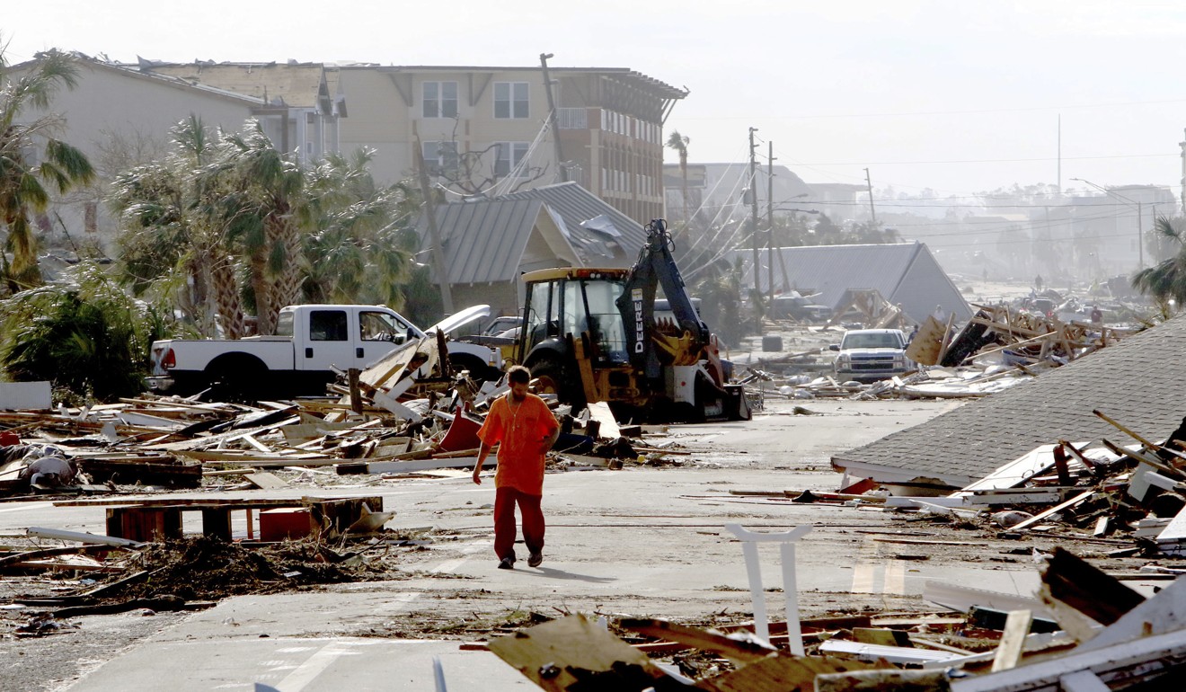 Robert Brock, 27, of Mexico Beach, walks westbound on US 98 through the coastal township, population 1,200, which lay devastated on Thursday. Brock said he stayed in the city to ride out the storm. Photo: Tampa Bay Times via AP