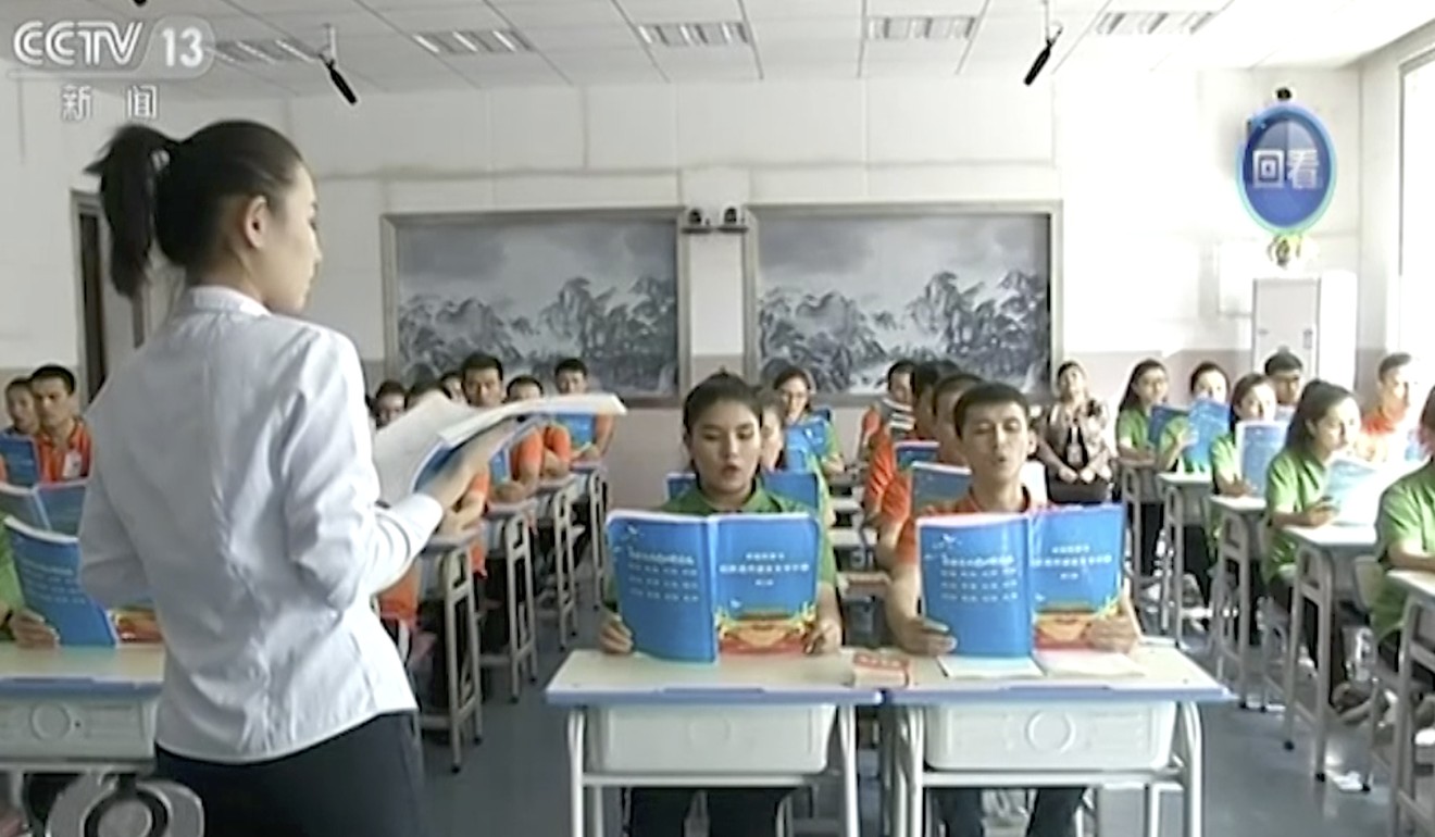 An image from an undated video purports to show young Muslims reading from official Chinese language textbooks in classrooms at the Hotan Vocational Education and Training Centre in Hotan, Xinjiang. Photo: AP Video