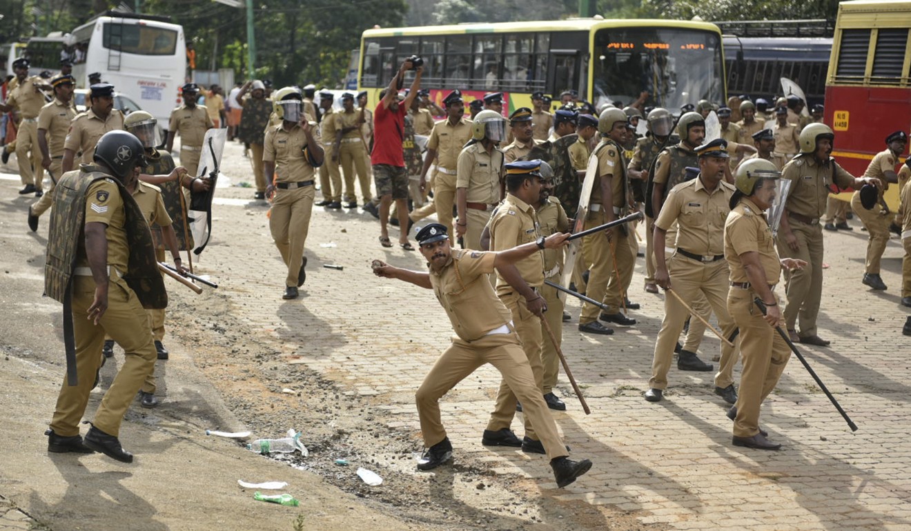 A policeman throws back a stone in clash with protesters who tried to stop women of menstruating age from going to the Sabarimala temple. Photo: AP