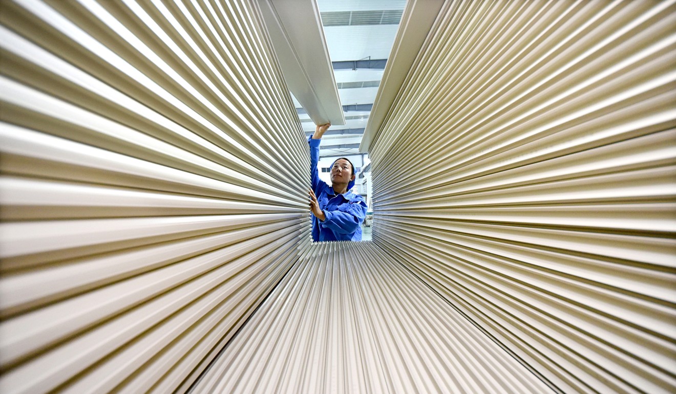 A worker arranges planks for export at the economic development zone in Yiyuan county, in east China’s Shandong province, on November 12. Photo: Xinhua