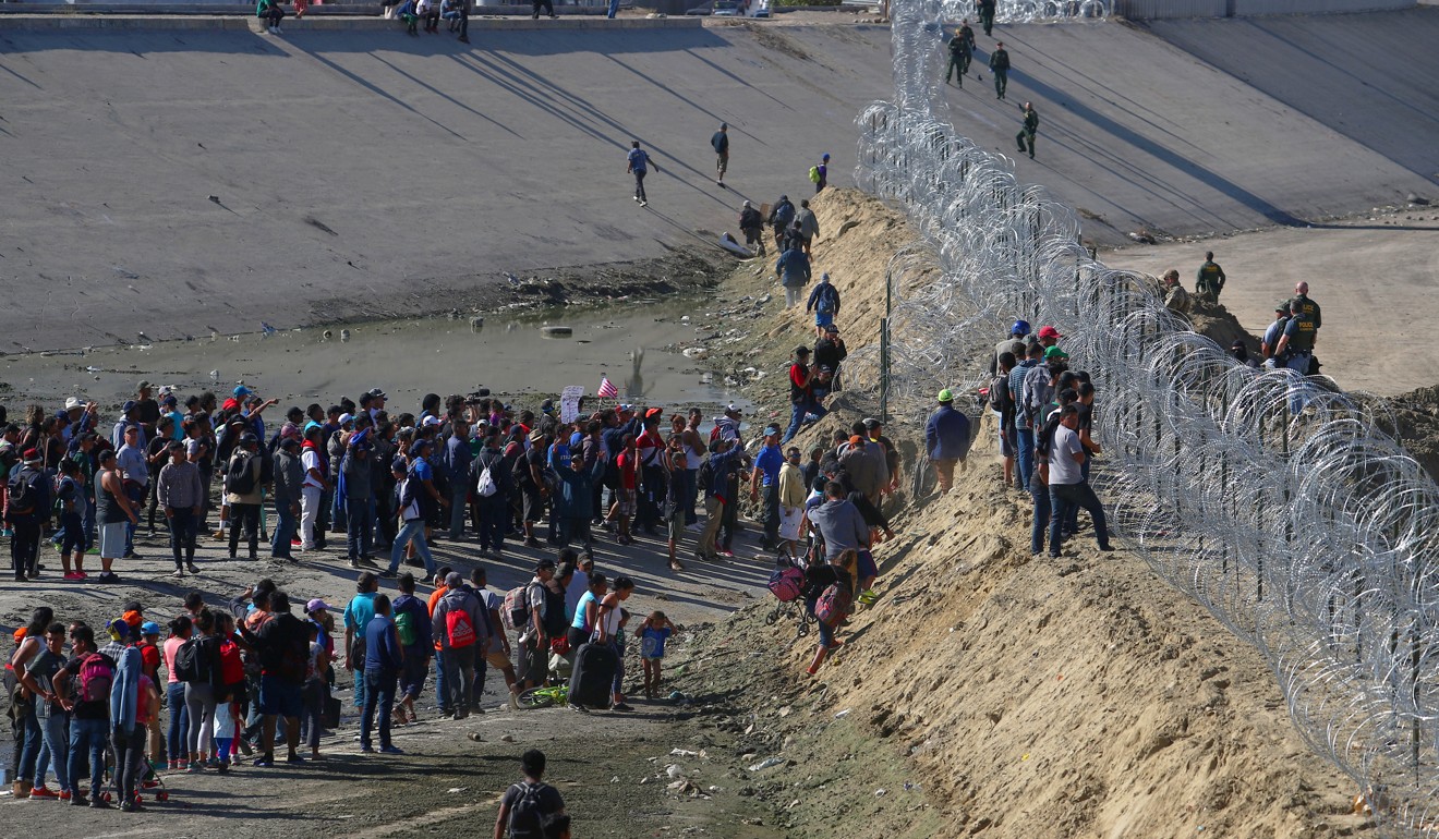 Migrants gather near the border fence between Mexico and the United States. Photo: Reuters