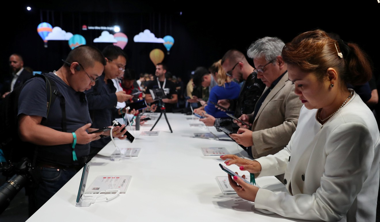 People look at models of the Huawei Mate20 smartphone series at a launch event in London. Photo: Reuters