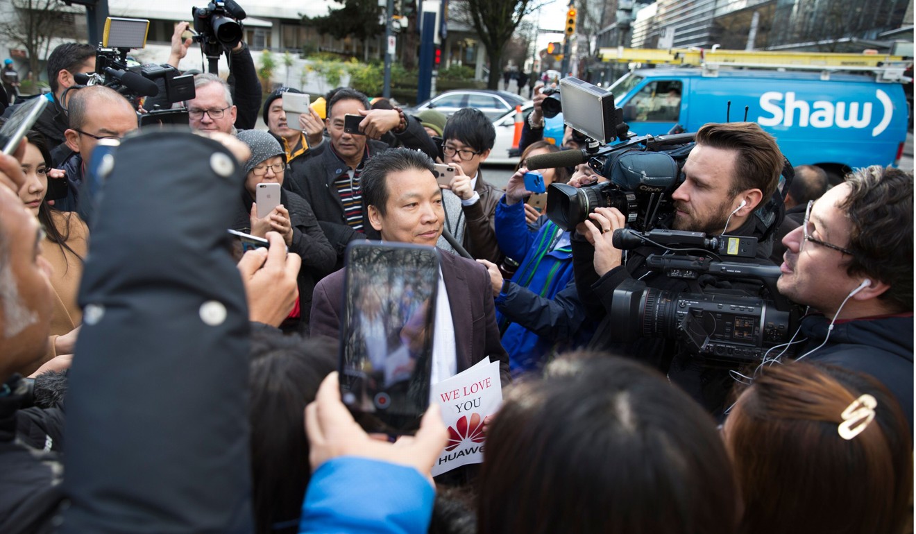 Joe Luo is swamped by media after they spot his pro-Huawei fliers. Photo: AFP