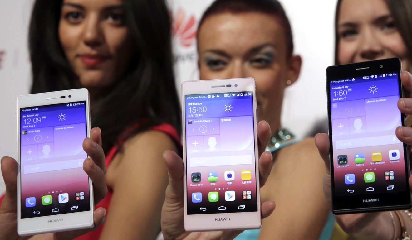 File photo of assistants holding up Huawei smartphones at a presentation in Paris. Photo: Reuters