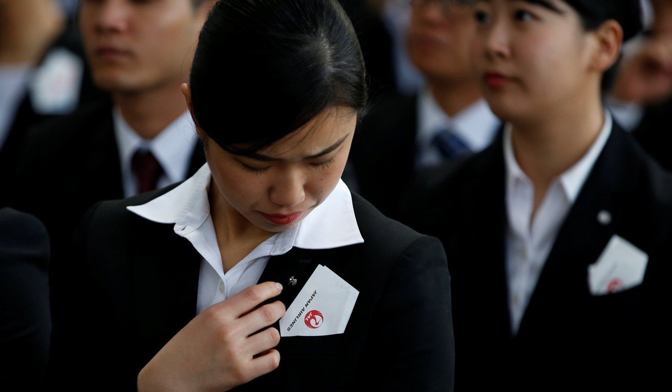 Newly-hired employees of Japan Airlines (JAL) at a company initiation ceremony in a hangar at Haneda airport in Tokyo in April 2018. Photo: Reuters