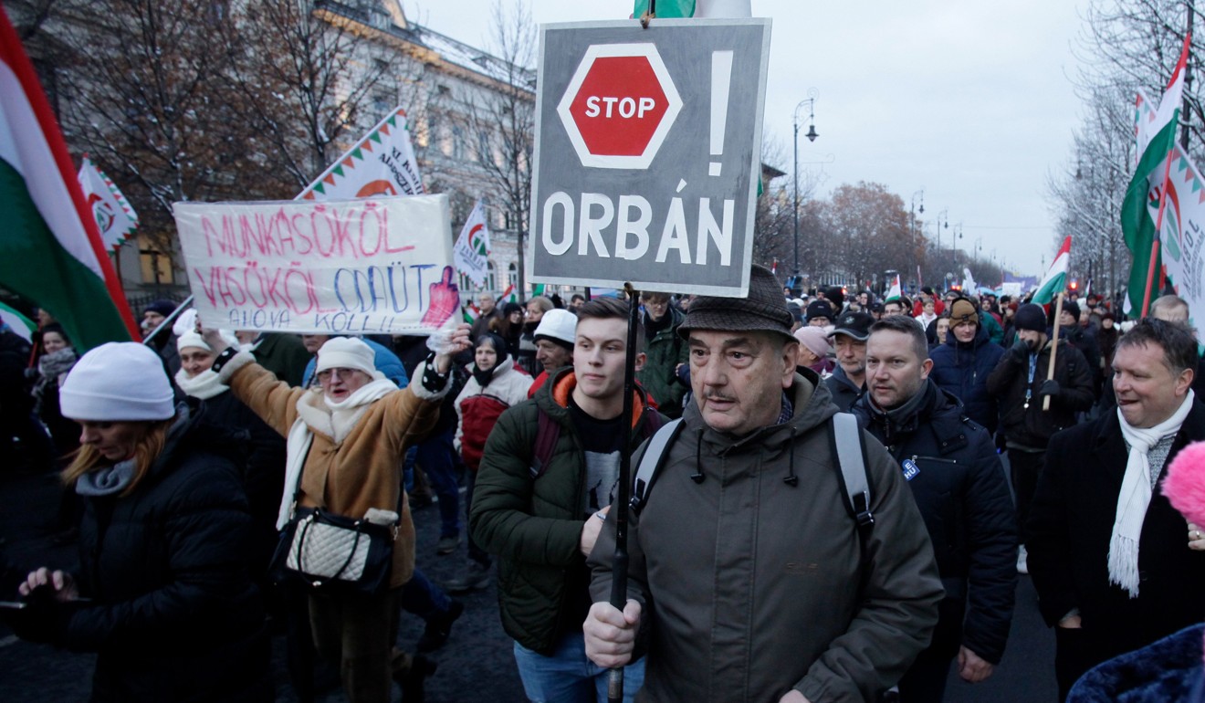 A protester holds a sign that reads ‘Stop Orban’. Photo: AFP