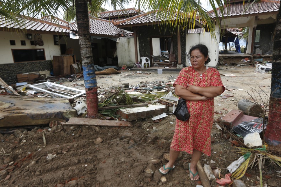 A tsunami survivor stands among debris in a devastated area in Carita, Banten. Photo: EPA