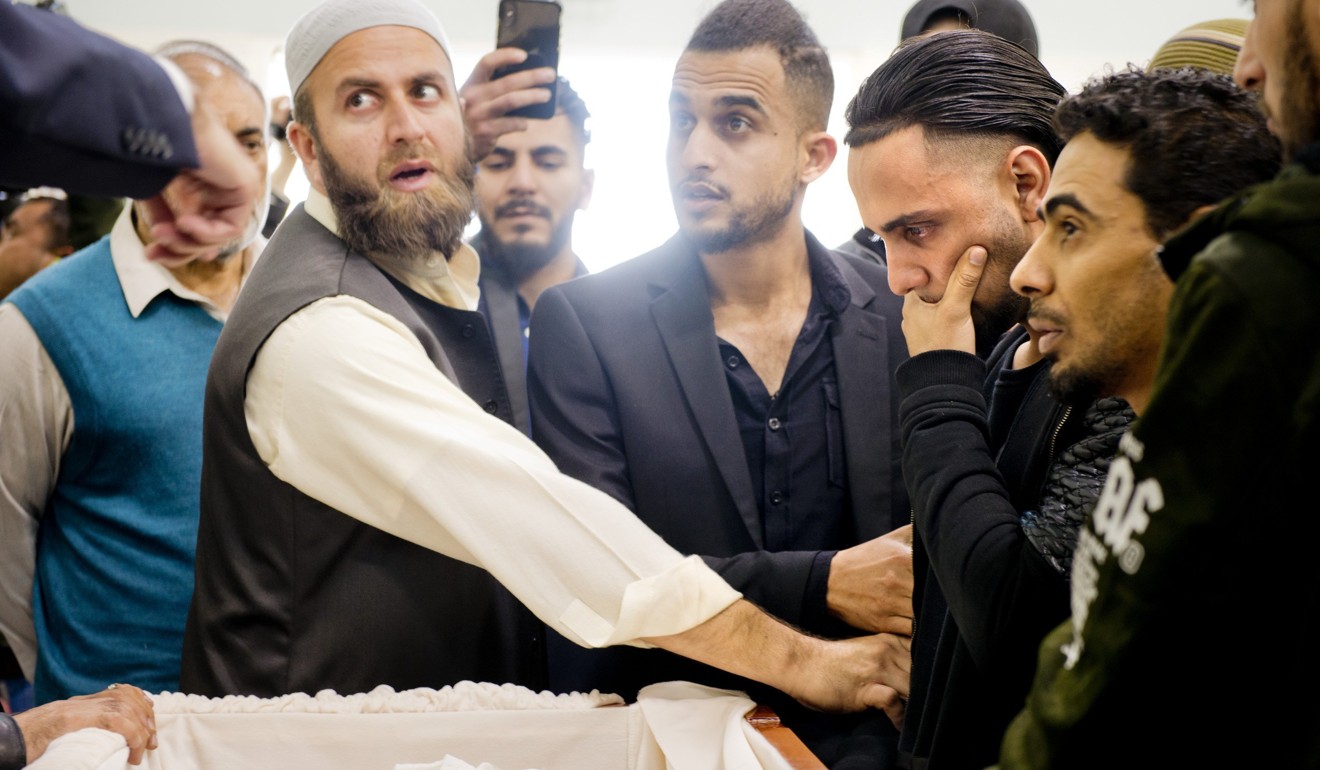 Ali Hassan, second from right, views the wrapped body of his two-year-old son, Abdullah Hassan, at his funeral. Photo: AP
