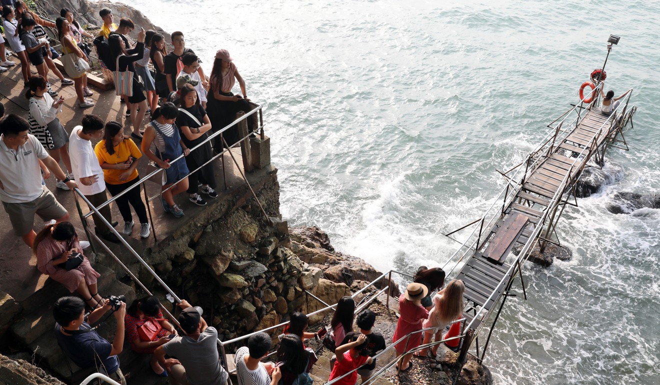 Mainland tourists visiting Hong Kong during the National Day holiday this year wait to take a photo at the Sai Wan swimming shed, which recently became popular with tourists. Photo: Robert Ng