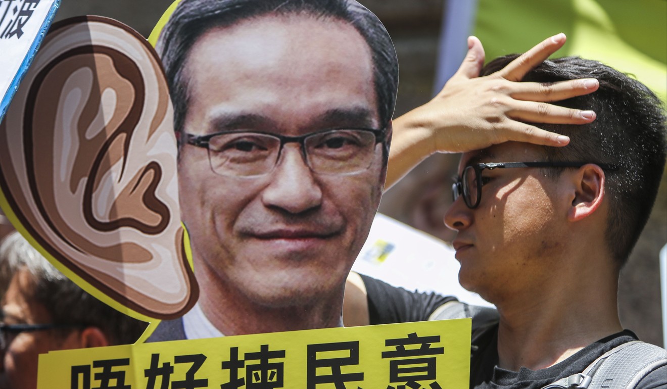A member of the public holds up a cardboard cutout of Stanley Wong during a protest against the Task Force on Land Supply. Photo: Winson Wong