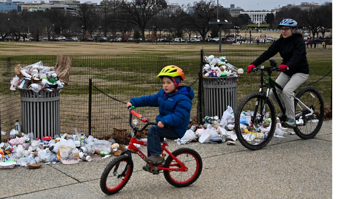 People ride past rubbish uncollected on the National Mall on January 2. Photo: AFP