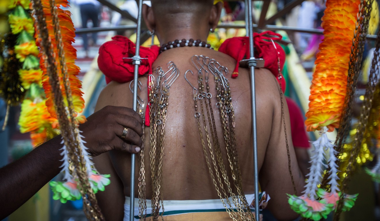 The Hindu body piercing festival Thaipusam in Malaysia: one man adding ...