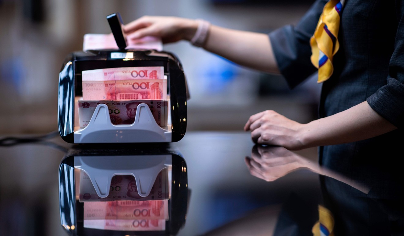 A bank employee uses a money counting machine to count out 100 yuan notes at a bank in Shanghai in August 2018. The yuan recovered some of its value versus the US dollar at the start of the year. Photo: AFP