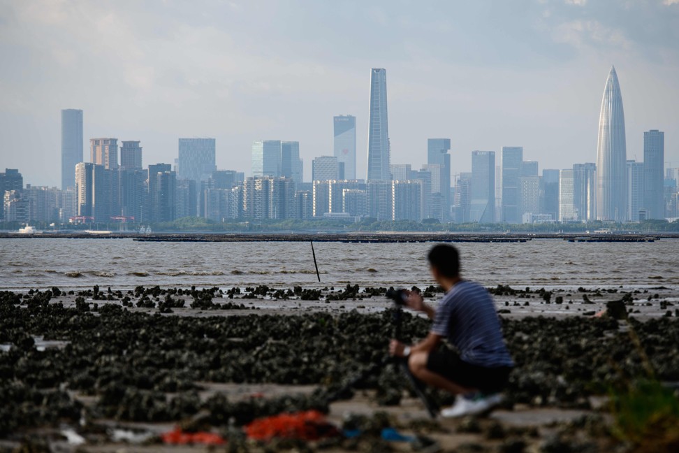 A man sets up his camera as he looks across Deep Bay towards Shenzhen's skyline from Hong Kong. Photo: Agence France-Presse