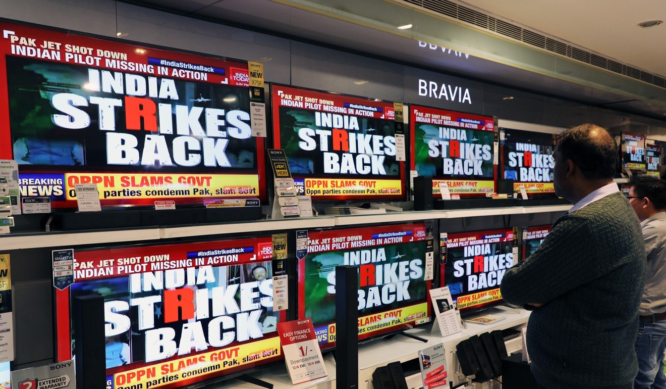 A man watches a news report on the conflict in an electronics store in New Delhi. Photo: Bloomberg