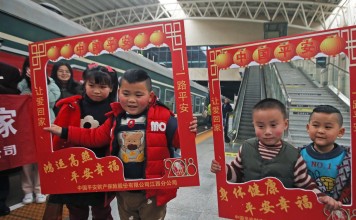 Children of migrant workers pose for photos before boarding a train from Shantou to Nanchang on February 10, heading home for family reunions to mark the Lunar New Year. Photo: Xinhua