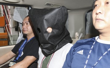 A drug trafficker is escorted away after a 15-year-old girl was apprehended at the Shenzhen Bay control point in possession of 20kg of cocaine. Picture: Dickson Lee