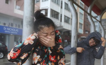 Storm chasers brave the heavy rain and strong wind in Kennedy Town when the No 10 typhoon signal was in force on September 16. Photo: Xiaomei Chen
