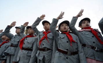 Primary school students dressed in replica red army uniforms and the Young Pioneer scarf at a ceremony in Beijing. Photo: Reuters