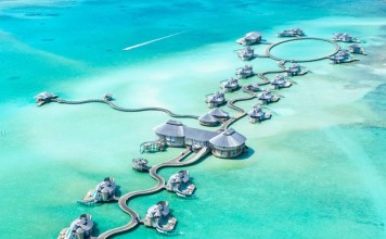 Splurge on luxurious overwater villas with direct access to the relatively shallow crystal clear waters below. Photo: Ishan @seefromthesky/Unsplash