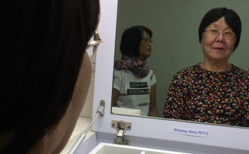 Cancer sufferer Ms Kin, not her real name, tries on a wig at the Hong Kong Cancer Fund branch in Kwai Chung, New Territories.