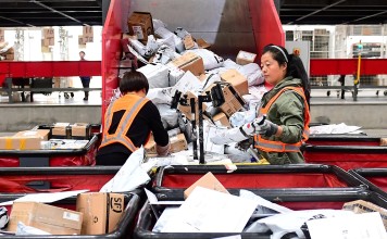 Workers sort parcels at an online shopping distribution centre in China. Photo: Reuters