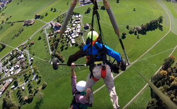 Florida man Chris Gursky (left) clings to his hang-gliding pilot in a video of his wild ride in Switzerland. Photo: Chris Gursky / YouTube