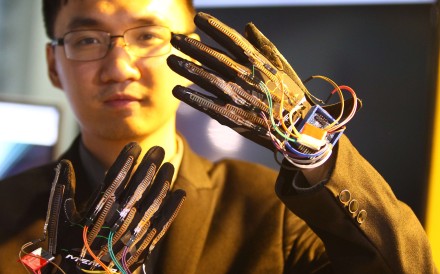 A staff member from Yingmi Tech, a firm based in Zhejiang province, shows off gloves developed with artificial intelligence technology that can do real-time translation of sign language into voice. The devices will be on display during the World Internet Conference in Wuzhen, which opened on Wednesday. Photo: Simon Song