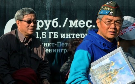 Chinese tourists wear Russian memorabilia in St Petersburg, Russia. Photo: AFP