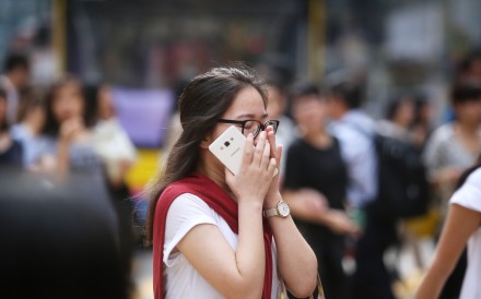 A woman covers her nose at a crossing in Causeway Bay, one of the most polluted areas in Hong Kong. Picture: SCMP
