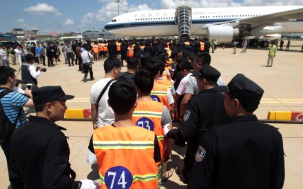 Chinese citizens who have been arrested over an alleged internet scam line up at the international airport in Phnom Penh, Cambodia, to be sent back to China, on Thursday. Photo: AP