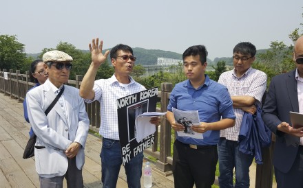 Hwang In-cheol (third left) on the Friendship Bridge in Panmunjeon with members of Seoul-based charity Teach North Korean Refugees and supporters in 2016 as he campaigns for his father’s return. Photo: Hwang In-cheol