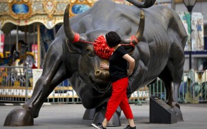 A Chinese woman touches a bull statue on display outside a mall in Beijing, in June. Data from the Institute of International Finance for the first week of November showed inflows of US$5 billion into China equities, the largest weekly total in four years. Photo: AP