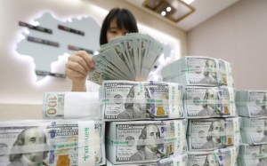 An employee looks at stacks of US dollars at the KEB-Hana Bank in Seoul. Should the US dollar begin to lose some of its strength, Asian currencies may be the ones to pick up the slack. Photo: EPA/Yonhap