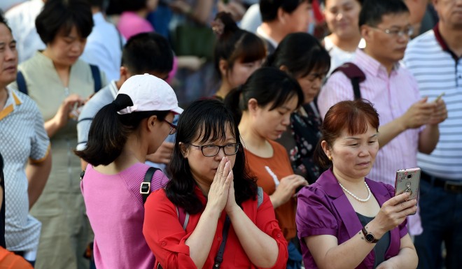 A parent prays outside a gaokao exam site in Hefei in eastern China in June 2017. Gaokao is a life-defining exam for many Chinese students.