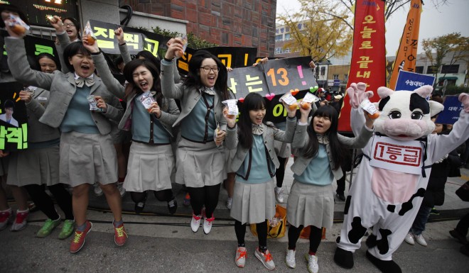 Students from a high school cheer for their seniors in front of a college entrance exam hall in Seoul, South Korea in 2012.