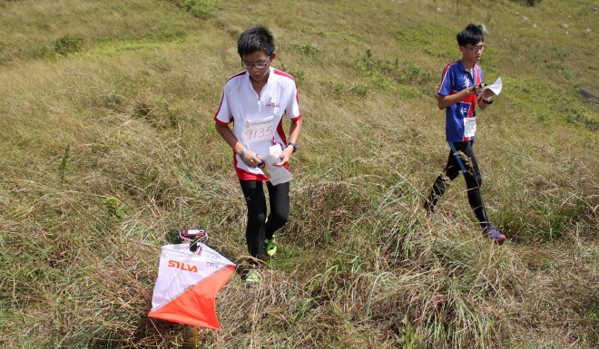 Youngsters locate a control point — an orange and white flag — in a field while taking part in an orienteering fun day event at the Hong Kong Velodrome Park last year. Photo: The Orienteering Association of Hong Kong