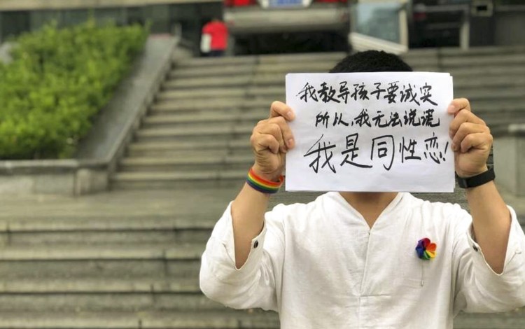 Kindergarten teacher Ming Jue holds up a sign that reads, 