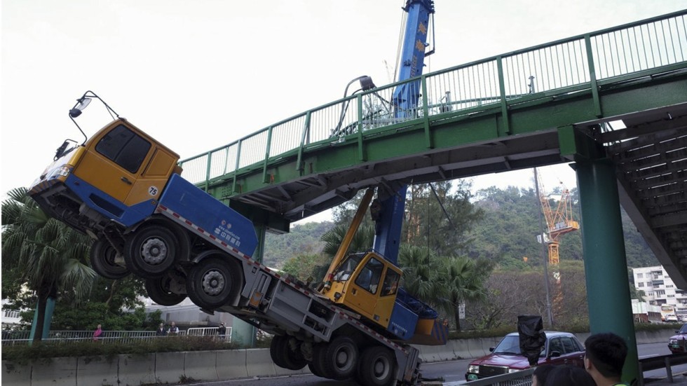 Hong Kong truck driver left hanging after crane smashes into bridge