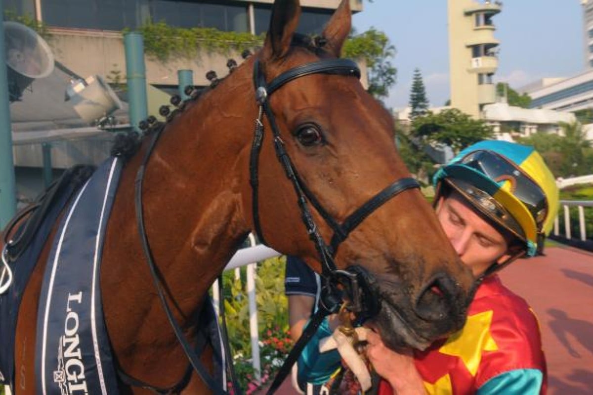 Zac Purton gives Ambitious Dragon a kiss after the Hong Kong star shrugged off injury to win the Mile in superb style. Photo: Kenneth Chan