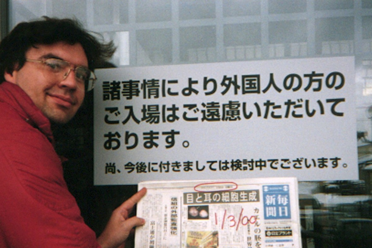 Debito Arudo in front of a Japanese bathhouse with a sign saying ‘Japanese Only’. Photo: Julian Ryall