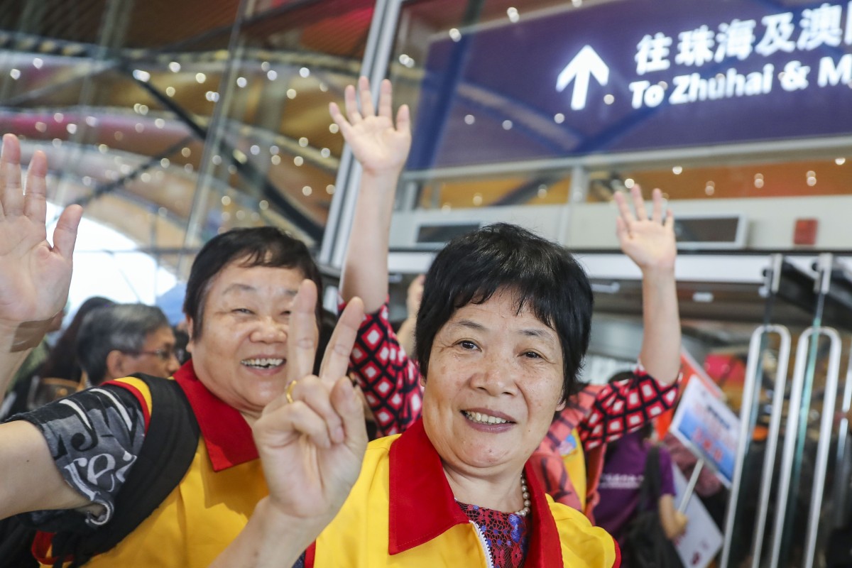 Excited passengers on cross-border coaches take selfies at the immigration clearance building   Hong Kong's transport secretary says he is not expecting large volume of traffic on first day of service