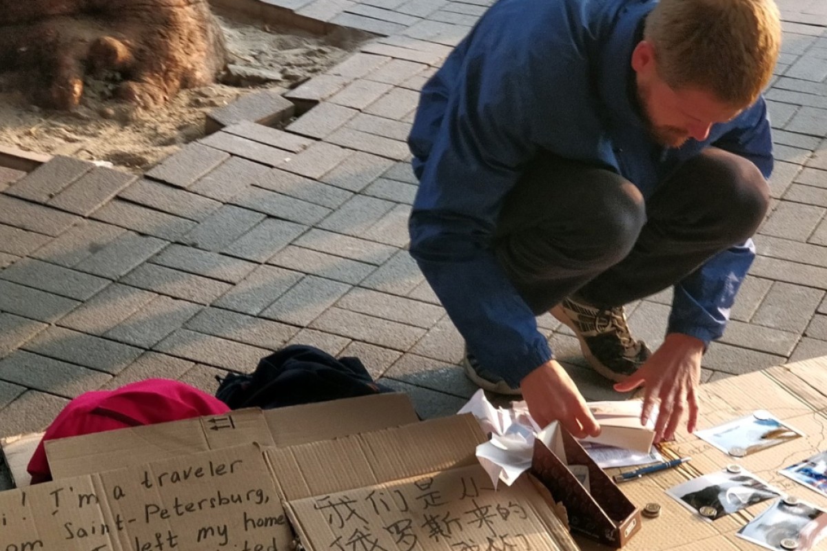 Some busk but others simply stand with signs asking for money, or smile to 'give back positive emotions' Cold shoulder from locals who see them as young, idle drifters is driving most away from city, especially with street acts dying out